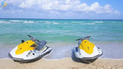 two jet skis sitting on the beach near the ocean at Alexander 604 in Miami Beach