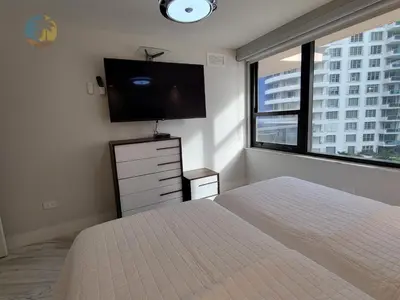 a bedroom with a bed and a flat screen tv at Alexander 611 in Miami Beach