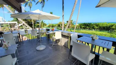 a patio with tables and chairs and an umbrella at Alexander 802 in Miami Beach