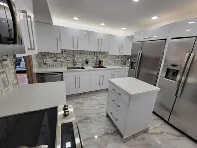a kitchen with white cabinets and stainless steel appliances at Alexander 807 in Miami Beach