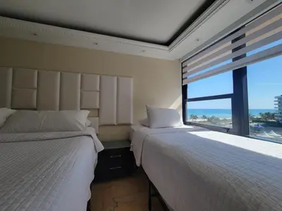 two beds in a room with a large window at Alexander 807 in Miami Beach
