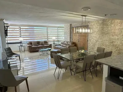 a dining room and living room with a table and chairs at Alexander 819 in Miami Beach