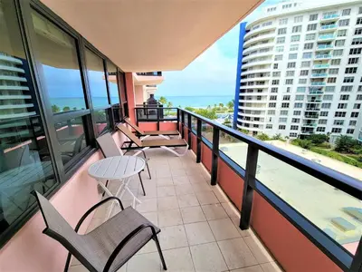 a balcony with chairs and a table and a view of the ocean at Alexander 819 in Miami Beach