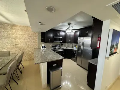 a kitchen with black cabinets and stainless steel appliances at Alexander 81921 in Miami Beach