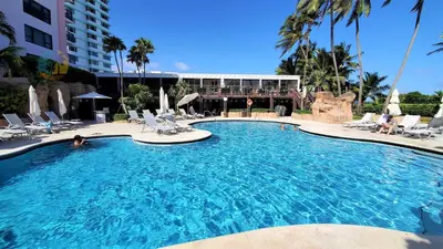 a large swimming pool with chairs and a building at Alexander 821 in Miami Beach