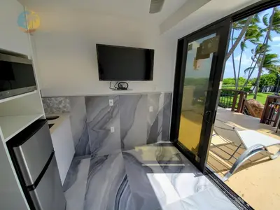 a living room with a tv and a sliding glass door at Alexander 901 in Miami Beach