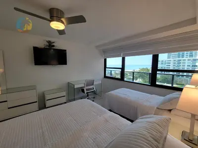 a bedroom with two beds and a flat screen tv at Alexander in Miami Beach