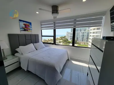 a bedroom with a bed and a large window at Alexander in Miami Beach