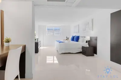 a white bedroom with a bed and a desk at Apartment 2BR 2BTH - Free Parking in Sunny Isles Beach