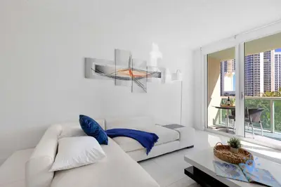 a white living room with a white couch and a window at Apartment 2BR 2BTH - Free Parking in Sunny Isles Beach
