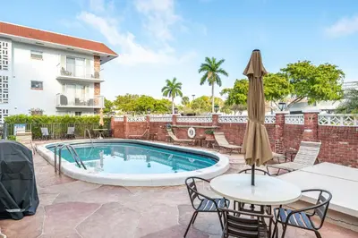 a patio with a pool and a table with an umbrella at Serenity Homes in Fort Lauderdale