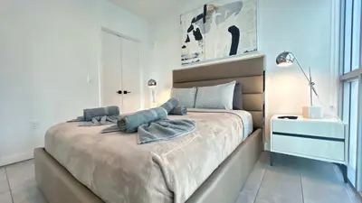 a bedroom with a large bed in a white room at Rare Corner Unit Private Terrace & Sunset Views in Miami