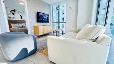 a living room with a white couch and a chair at Rare Corner Unit Private Terrace & Sunset Views in Miami