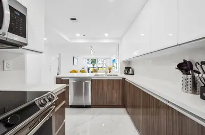 a white kitchen with a sink and a stove at The Grand Wonder Biscayne in Miami