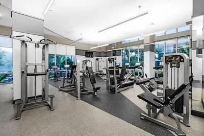 a gym with several treadmills and elliptical machines at Sunny 1BR Unit With Free Parking Prime Location in Miami