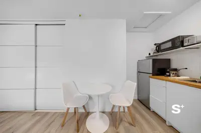 a kitchen with three white chairs and a table at Chic Miami Studio - Gym, BBQ, Free Parking in Miami