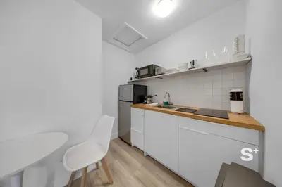 a kitchen with white cabinets and a counter top at Chic Miami Studio - Gym, BBQ, Free Parking in Miami