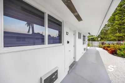 a white building with a large window on the side at Chic Miami Studio - Gym, BBQ, Free Parking in Miami