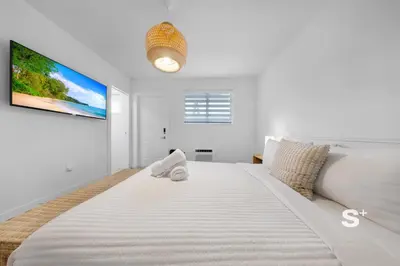 a large white bedroom with a large white bed at Chic Miami Studio - Gym, BBQ, Free Parking in Miami