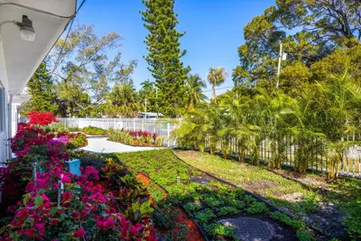 a garden with flowers and a fence at Stylish Studio - Parking & Gym Near Aventura in Miami