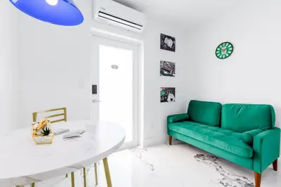 a living room with a green couch and a white table at Havana Casino in Miami