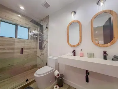a bathroom with a toilet and a sink and mirror at Designer 1BR Retreat Heart of Miami Pool in Miami