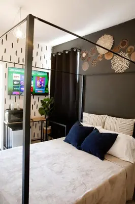 a bedroom with a large bed and two televisions at Boho Oasis 2 in Homestead