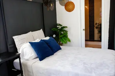 a bedroom with a bed with blue and white pillows at Boho Oasis 2 in Homestead