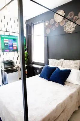 a bedroom with a large bed with blue pillows at Boho Oasis 2 in Homestead