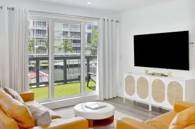 a living room with a tv and a large window at Orange Dream in the Sky in Fort Lauderdale