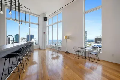 an empty room with a table and chairs and large windows at Art-filled Loft 180 Views, Rooftop Pool, Parking in Miami