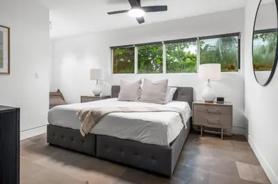 a bedroom with a large bed and two windows at Luxury Miami Villa with Large Pool & BBQ, Perfect Getaway! in Miami