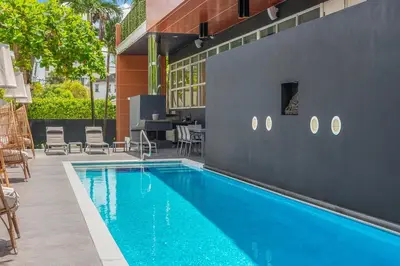 a swimming pool with chairs and a table next to a building at Luxury Miami Villa with Large Pool & BBQ, Perfect Getaway! in Miami