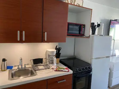 a small kitchen with a sink and a refrigerator at Departamento sobre la Playa con vista a la Collins Ave in Sunny Isles Beach