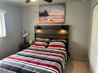 a bedroom with a bed with a striped blanket at Hollywood Happiness in Hollywood