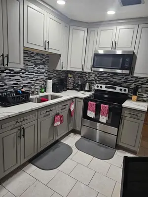 a kitchen with white cabinets and a stove top oven at Hollywood Happiness in Hollywood