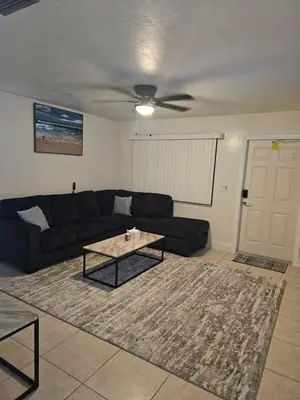 a living room with a black couch and a coffee table at Hollywood Happiness in Hollywood