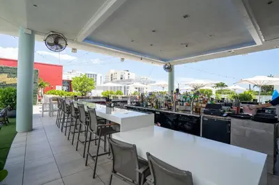 a bar with white tables and chairs on a patio at Splendid apartment for 4 pax partial view of the beach in Hollywood M in Hollywood