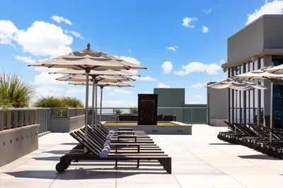a row of benches with umbrellas on a patio at Splendid apartment for 4 pax partial view of the beach in Hollywood M in Hollywood