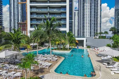 an overhead view of a pool with palm trees and buildings at Modern DTW Miami Escape with Water Views in Miami