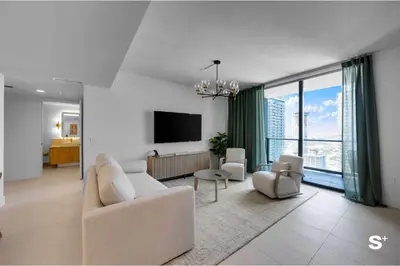 a living room with a couch and a tv at Modern DTW Miami Escape with Water Views in Miami