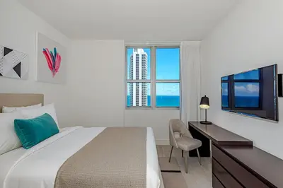 a bedroom with a bed and a desk and a television at Miami Escape Views & Amenities in Hollywood