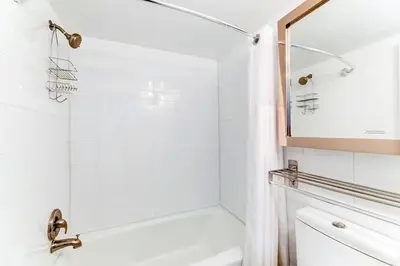 a white bathroom with a shower and a mirror at Entire townhouse Ft Lauderdale in Fort Lauderdale