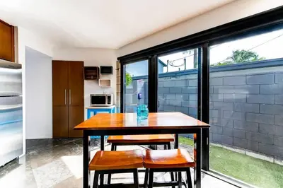 a kitchen with a wooden table and some chairs at Entire townhouse Ft Lauderdale in Fort Lauderdale