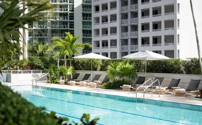 a swimming pool with lounge chairs and umbrellas at Brickell-AKA Free Parking by Palermo Home Miami in Miami
