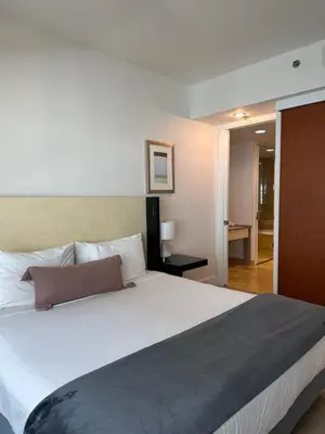 a bedroom with a large white bed and a hallway at Brickell-AKA Free Parking by Palermo Home Miami in Miami