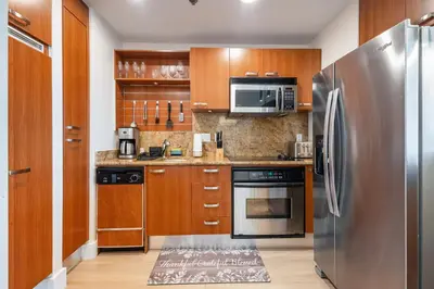 a kitchen with wooden cabinets and a stainless steel refrigerator at Brickell AKA 32th Free Parking by Palermo Home Miami in Miami