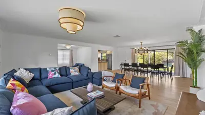 a living room with a blue couch and chairs at Luxury Miami Waterfront Retreat with Private Dock in Golden Glades