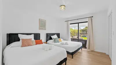 two beds in a room with a window at Luxury Miami Waterfront Retreat with Private Dock in Golden Glades