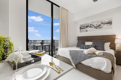 a bedroom with a bed and a bathroom with a sink at Luxury Studio with Stunning City Views in Miami